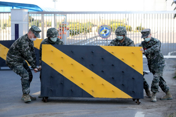 韩国某部队正门前,官兵们设置路障防疫(韩联社)