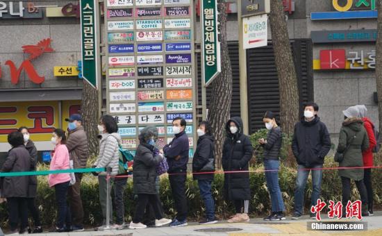 3月1日,在首尔钟路区一家超市外,民众排起长队等待购买口罩。中新社记者 曾鼐 摄