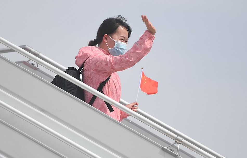 3月18日,乘机抵达石家庄正定国际机场的河北省援鄂医疗队队员向接机人员挥手致意。新华社记者 朱旭东 图