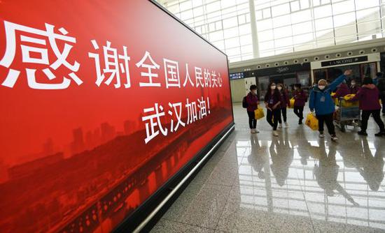 3月17日,准备登机的天津医疗队经过武汉天河机场候机楼内一处感谢标语。 (新华社)
