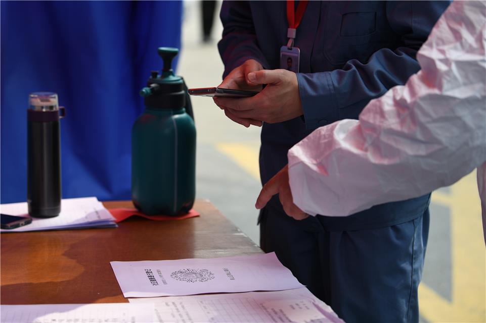 3月23日,武汉市青山区青山镇街石化社区,居民通过扫绿码进入小区。