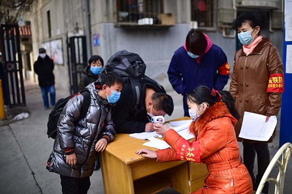 3月3日,在青海省西宁市中庄社区的疫情防控点,志愿者为进入小区的人员做信息登记、体温测量和健康宣传等工作。 新华社 图