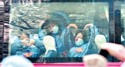 3月31日,福建援鄂医疗队登上返程大巴,医疗队队员与武汉医护人员“比心”道别 长江日报记者郭良朔 摄