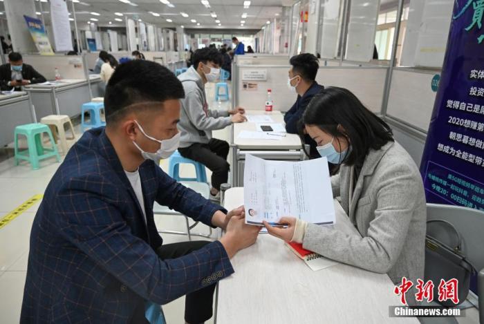 4月14日,招聘者在查看求职者简历。中新社记者 王刚 摄
