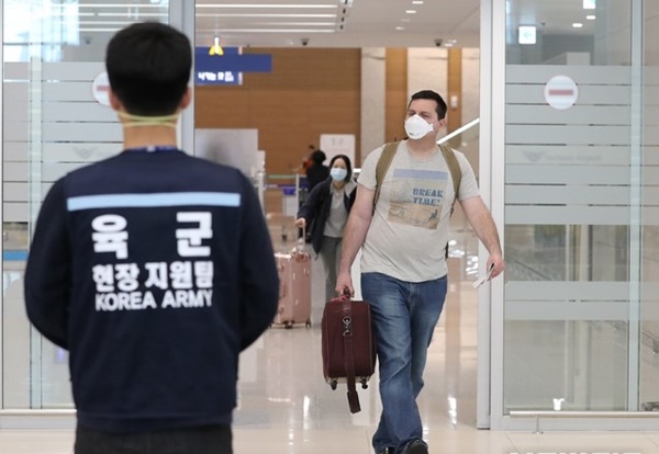 资料图:一名外籍人员戴口罩现身韩国机场