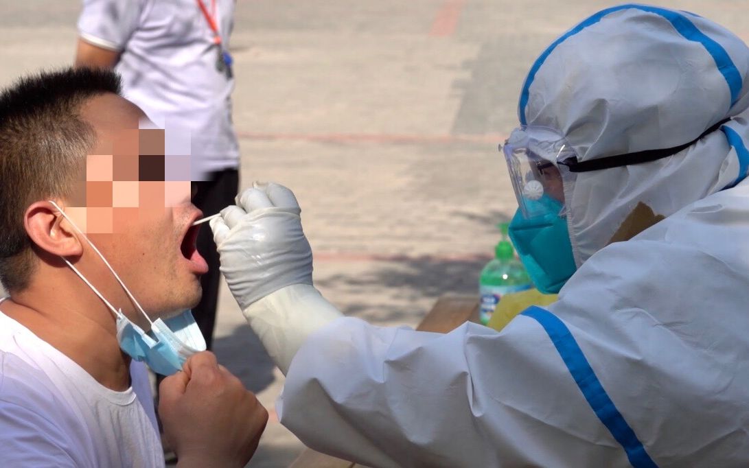 6月16日下午,丰台区卢沟桥街道青塔街心公园核酸检测点内,医务人员正在采集咽拭子。新京报记者 吴淋姝 摄