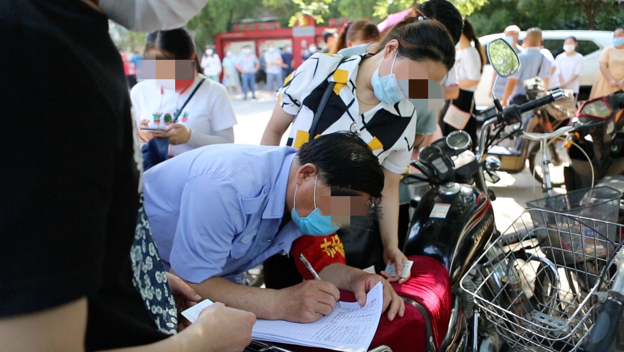 6月16日下午,丰台区卢沟桥街道青塔街心公园核酸检测点外,居民正在登记。新京报见习记者 赵敏 摄