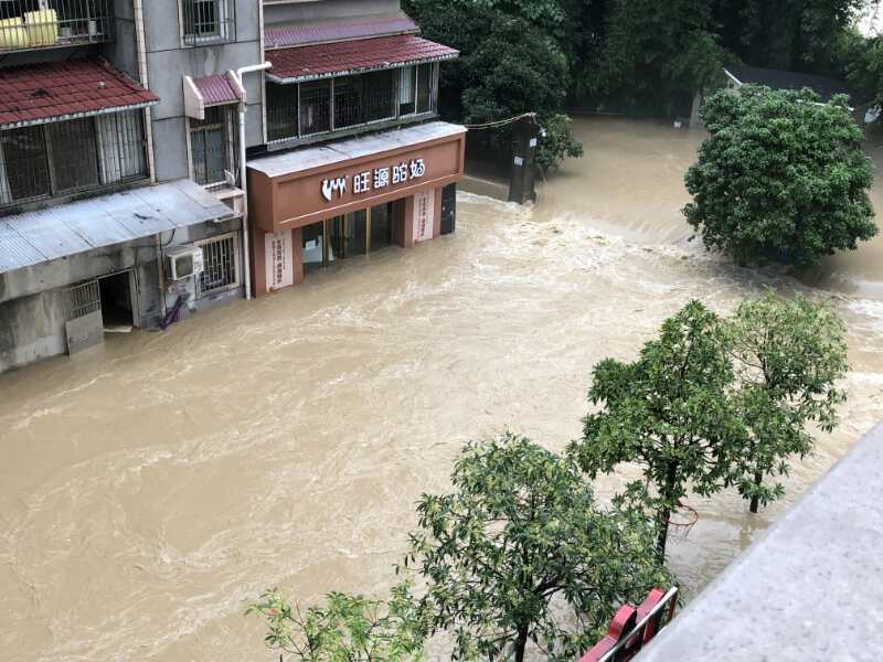 7月17日下午,清江河水漫过亲水走廊倒灌入城区,形成瀑帘,一楼商铺被淹。 受访者供图