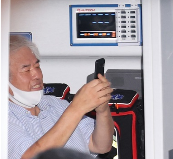 牧师全光勋确诊后,在救护车上开心玩手机(韩联社)