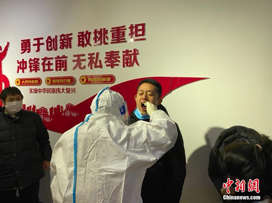 环卫工人介绍,给他们做核酸检测的疾控中心工作人员也非常辛苦,白天在给各个单位做检测,晚上又是奋战一夜。据国家卫健委通报,1月5日0—24时,河北新增本土新冠肺炎确诊病例20例。图为环卫工在进行核酸检测。 杨帆 摄