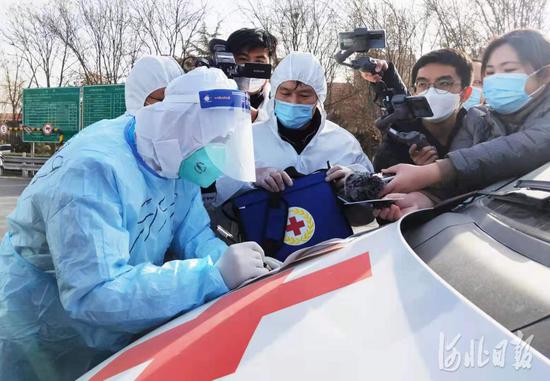 石家庄裕华路高速口,石家庄市红十字会工作人员正在与北京市红十字会紧急救援中心(999)工作人员(左一)进行交接。河北日报记者赵海江摄