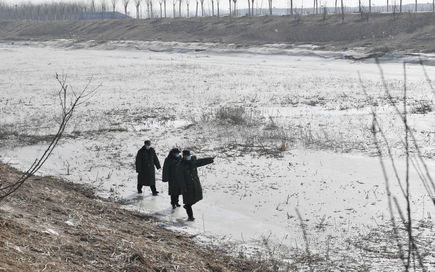 1月12日，礼贤镇综治办工作人员在冰冻的永定河河道内巡逻。新京报记者 李木易 摄