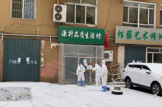 在通化市源升品质养生坊门外,几名疾控部门工作人员正在工作。图片据新华社