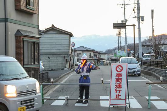 ▲2月14日,日本福岛县桑折町一处因地震受损的房屋附近道路被封锁。新华社记者 杜潇逸 摄