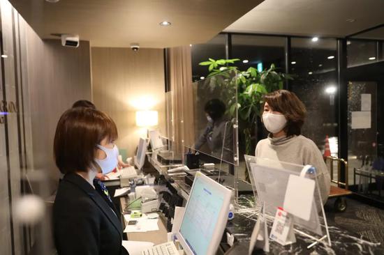 ▲2月15日,在日本福岛县相马郡,韩秋月(右)在温泉酒店询问前台工作人员营业情况。新华社记者 杜潇逸 摄